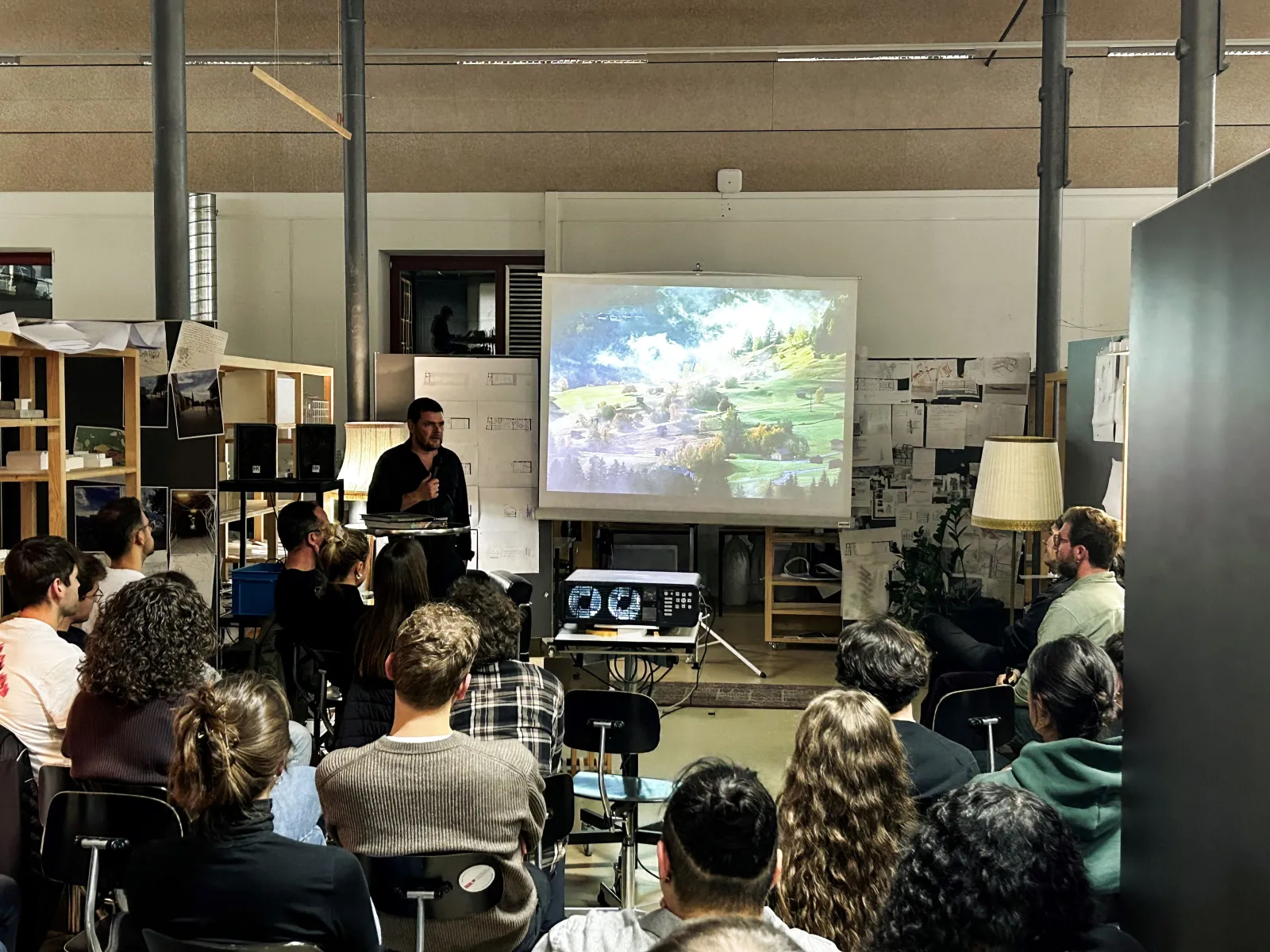 Vortragender in einem Atelier vor vielen Studierenden