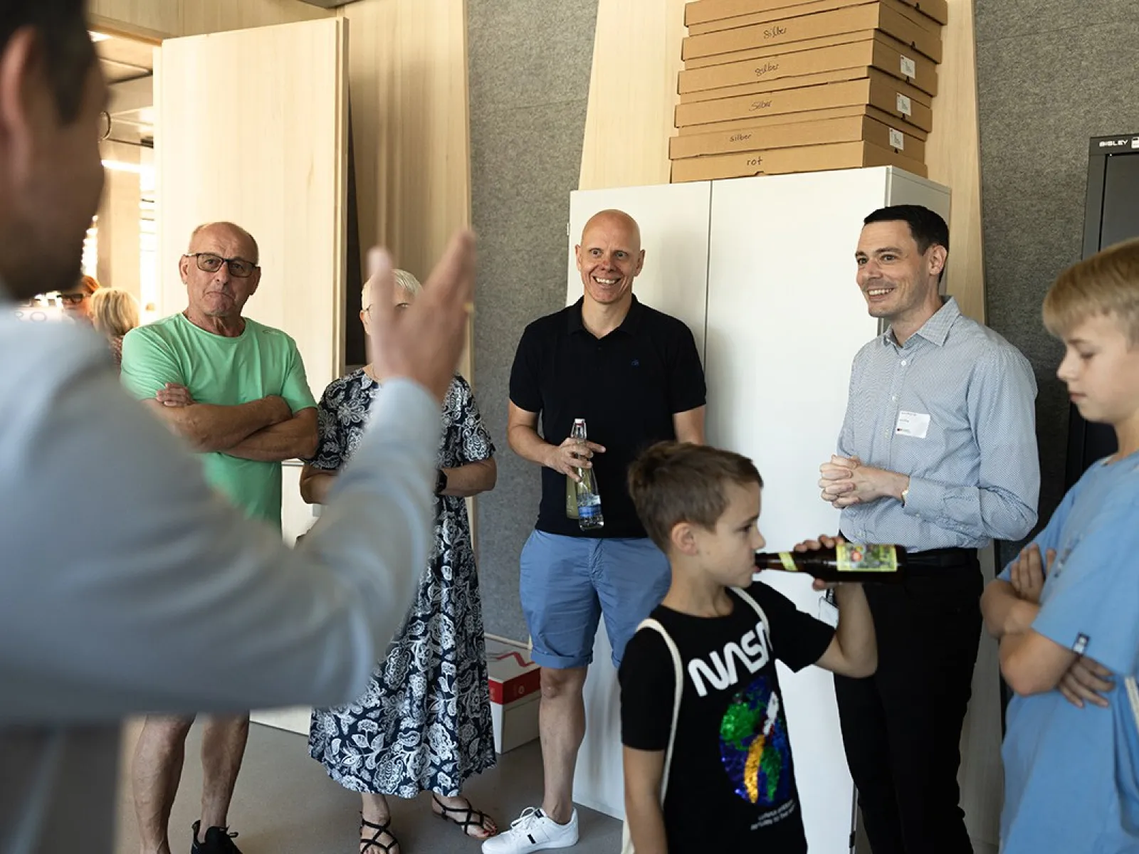 Gruppe von Menschen bei einer Führung im neuen Standort der Universität Liechtenstein, Ebaholz, während des Tags der offenen Tür. Ein Mann spricht zu den Besuchern, die aufmerksam zuhören.
