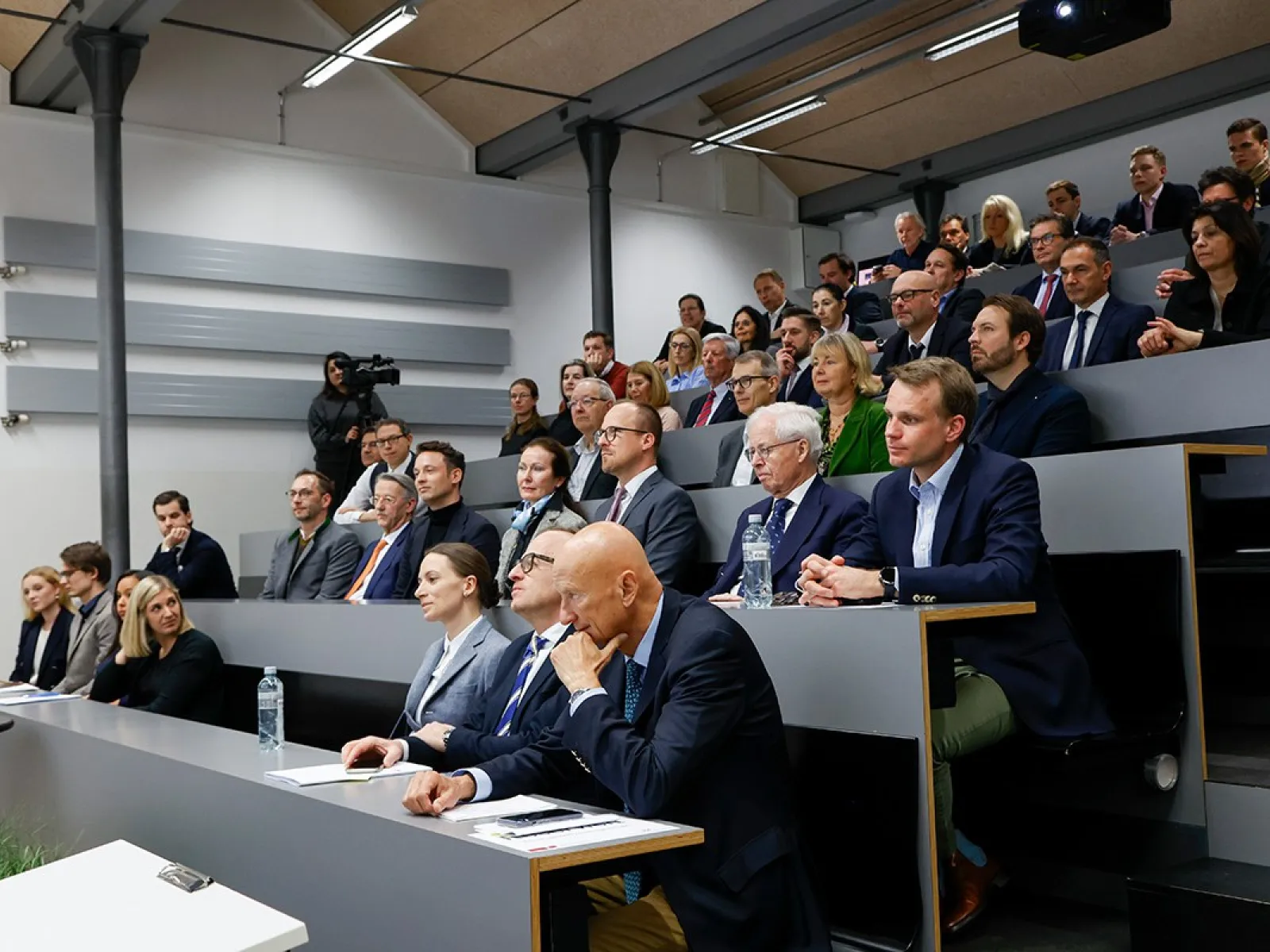Ein vollbesetzter Hörsaal an der Universität Liechtenstein, in dem Studierende und Fachleute aufmerksam einer Präsentation folgen.
