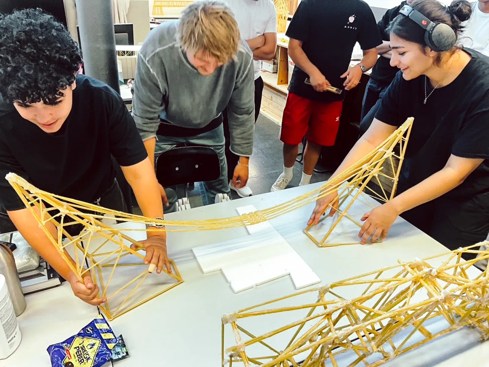 Studierende bauen eine Brücke aus Spaghettinudeln