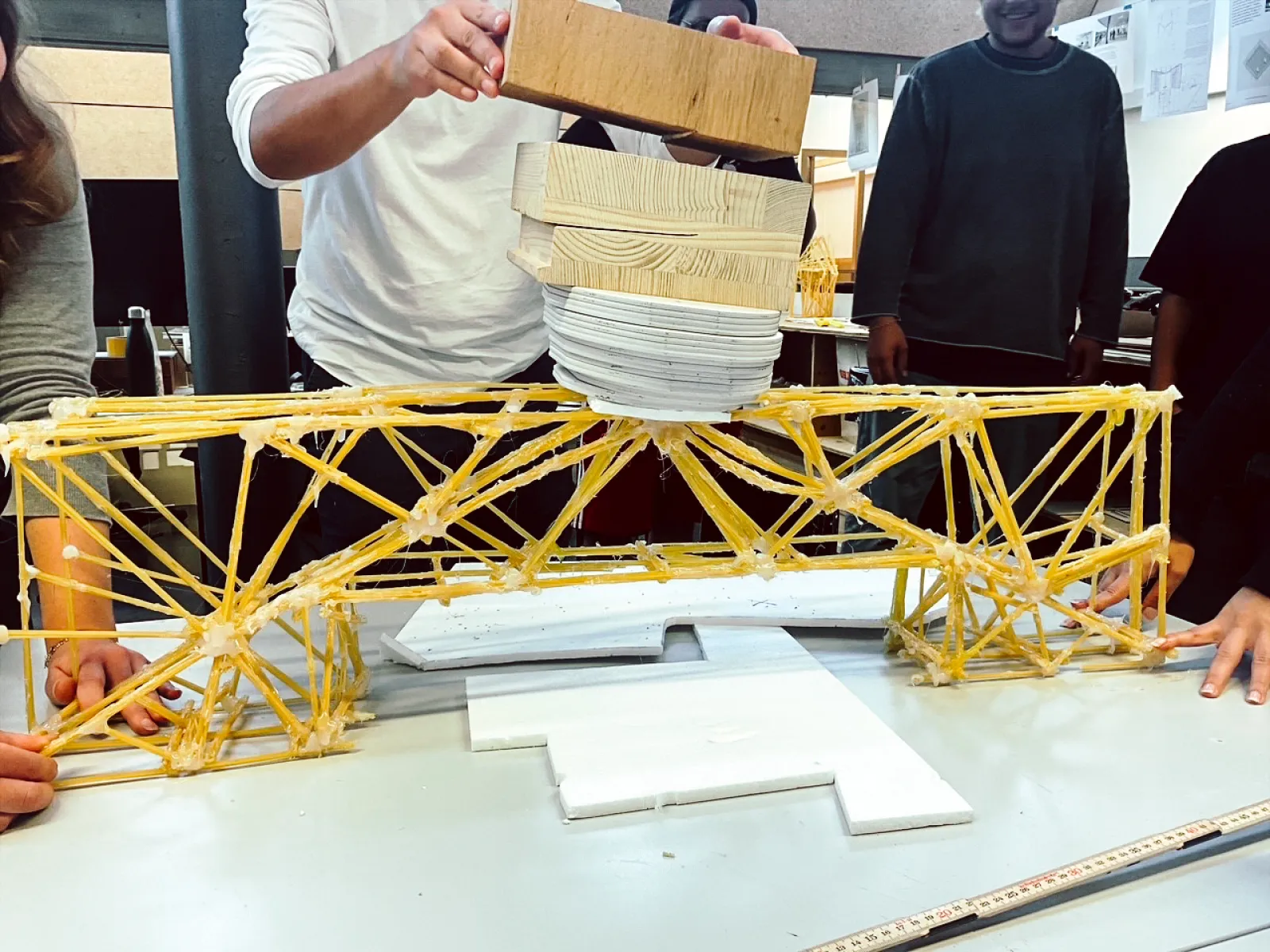 Brücke aus Spaghettinudeln mit Menschen im Hintergrund