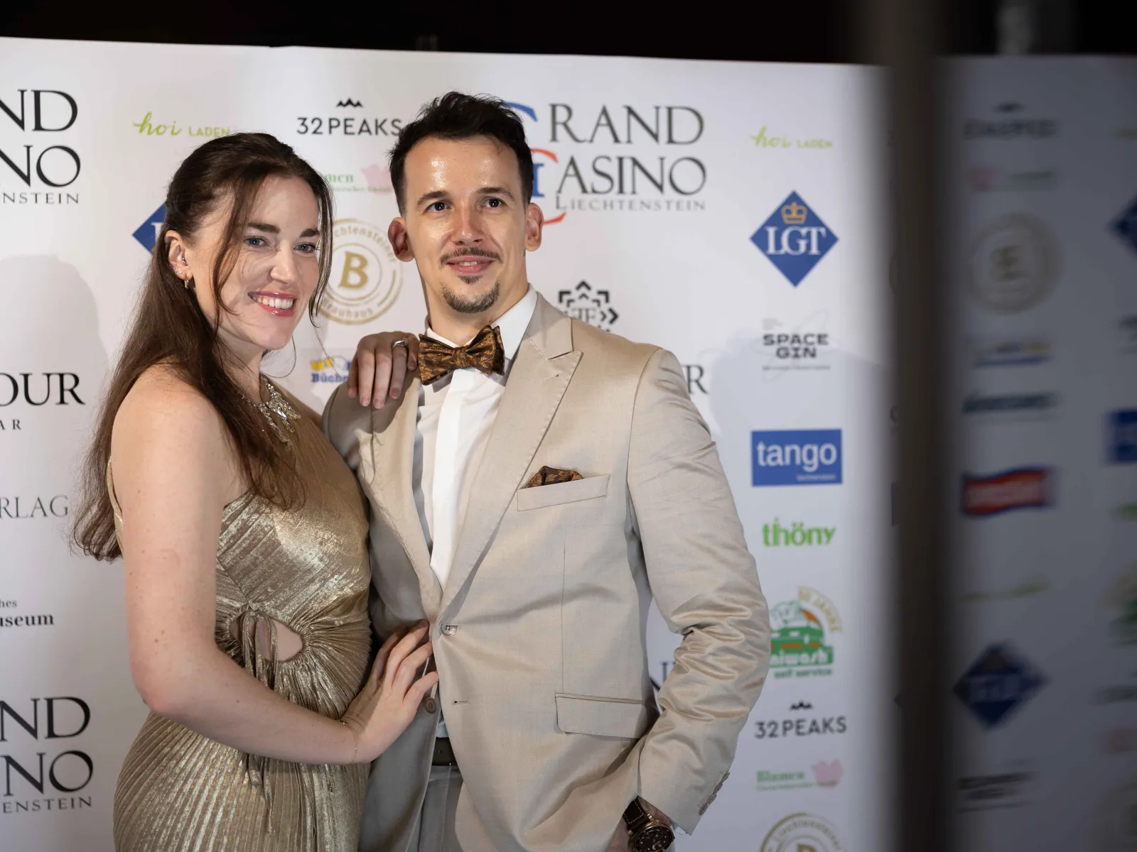 Paar-posiert-vor-Sponsorenwand-Uniball-Uni-Liechtenstein