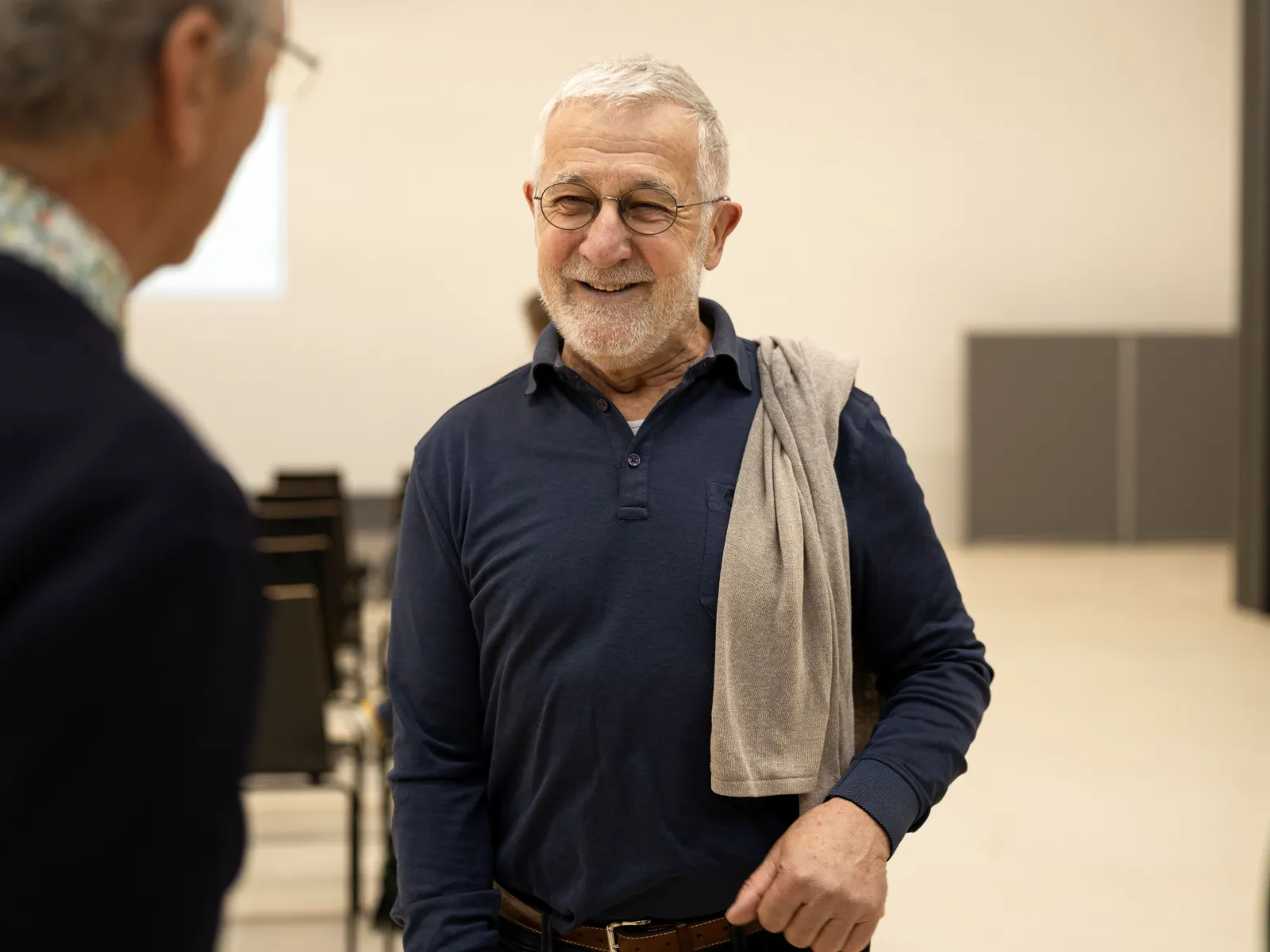 Bild von einem Mann mit grauen Haaren, Brille und blauem Pullover