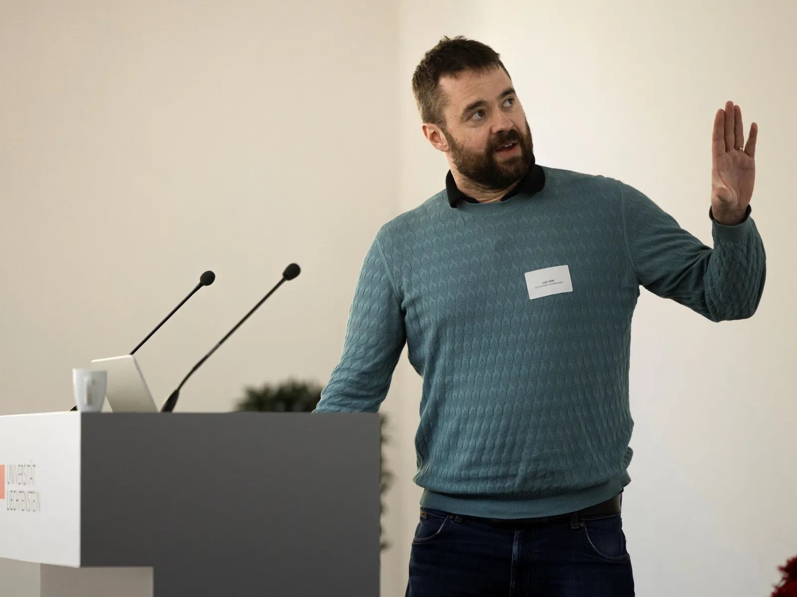 Mann mit blauem Pullover bei einem Vortrag