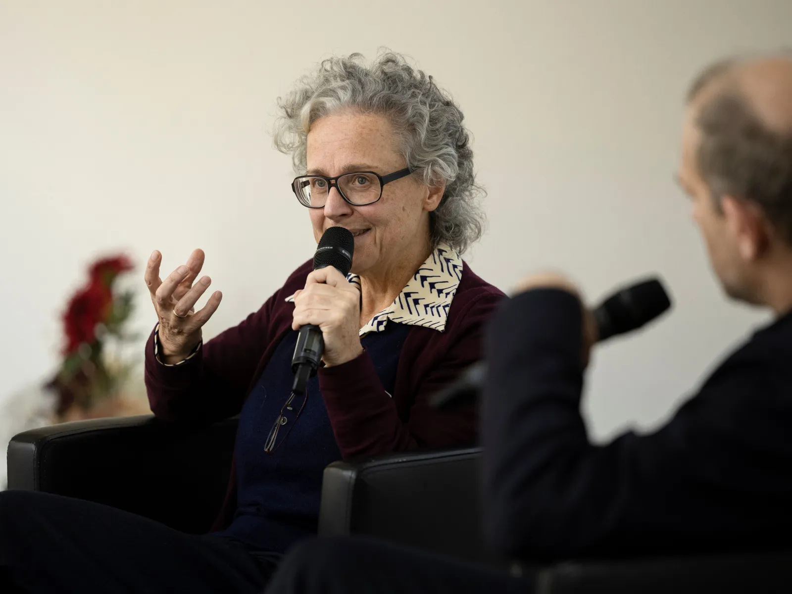 Frau mit Brille und Mikrofon bei einem Vortrag