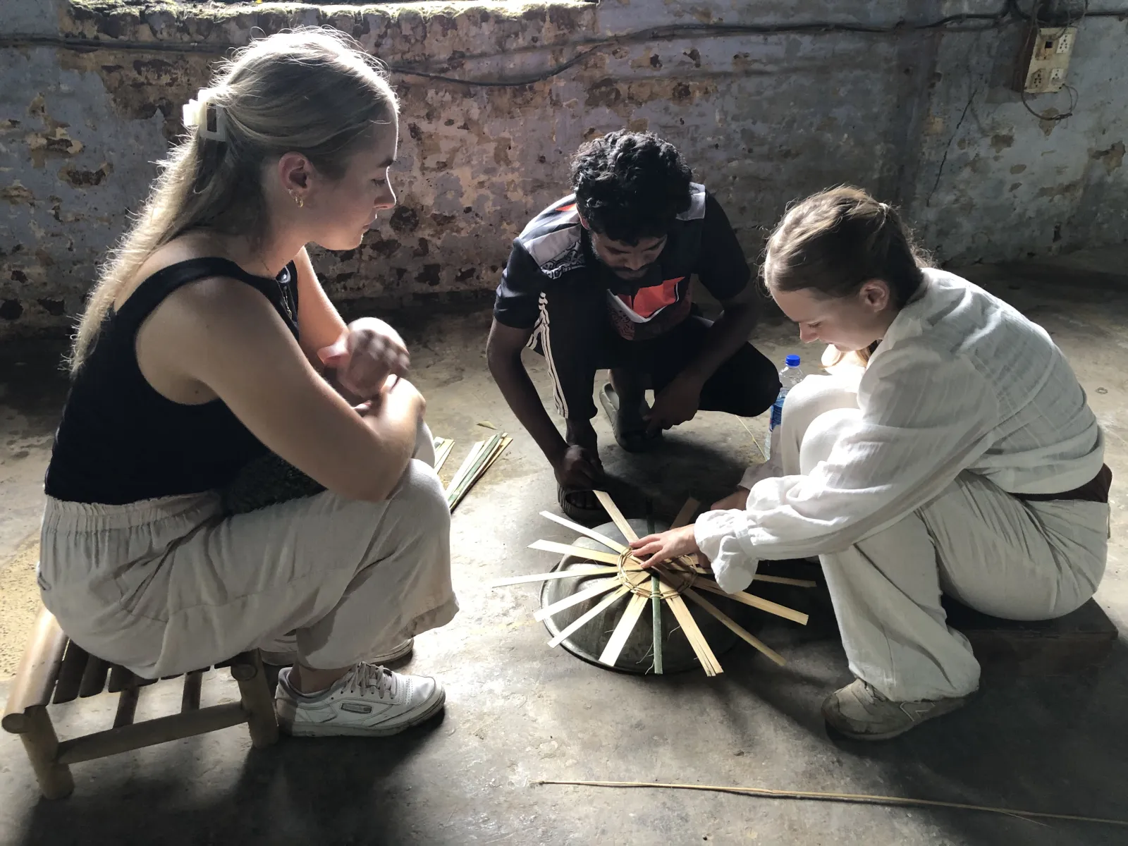 Drei Menschen mit einem kleinen Modell in der Mitte