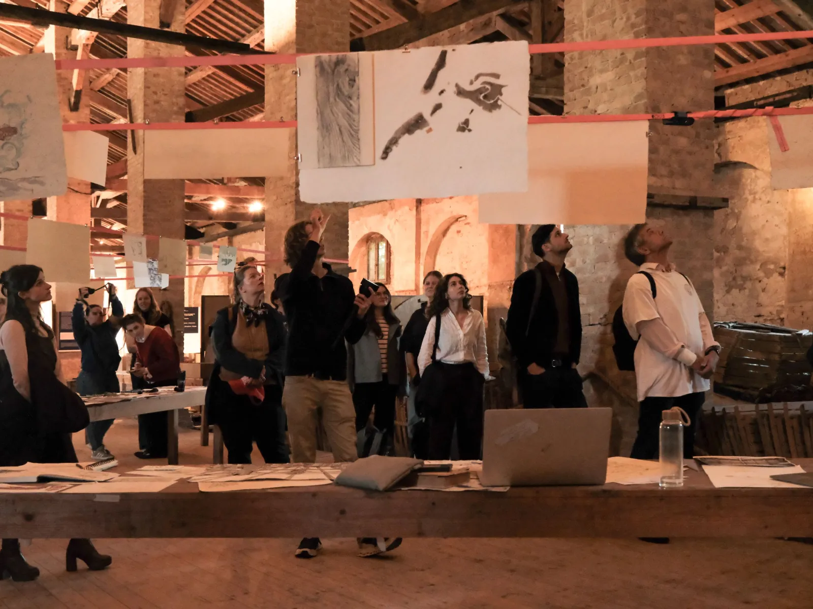 Bild in Brauntönen mit Menschen in einer Ausstellung