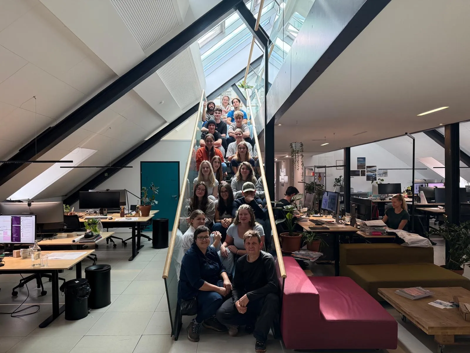 Gruppenbild junger Menschen auf einer Treppe in einem Atelier