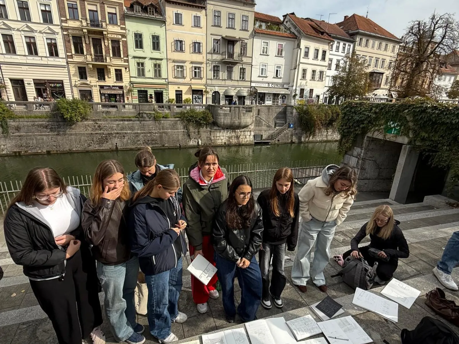 Junge Menschen vor Skizzen mit Häusern im Hintergrund