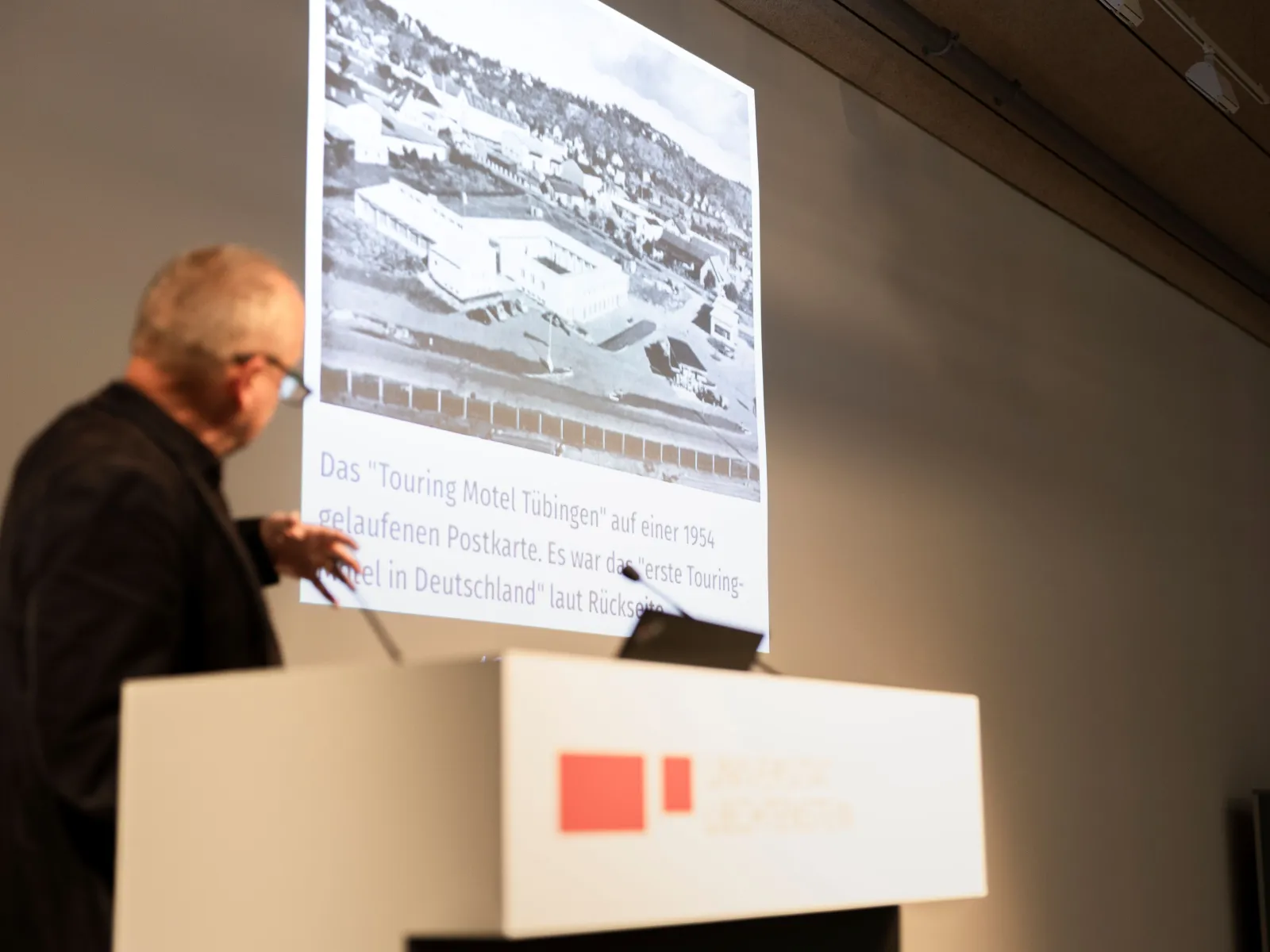 Eine Person präsentiert an einem Vortragspult