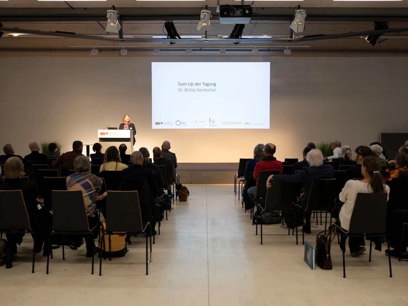 Eine vortragende Person auf einer Bühne 