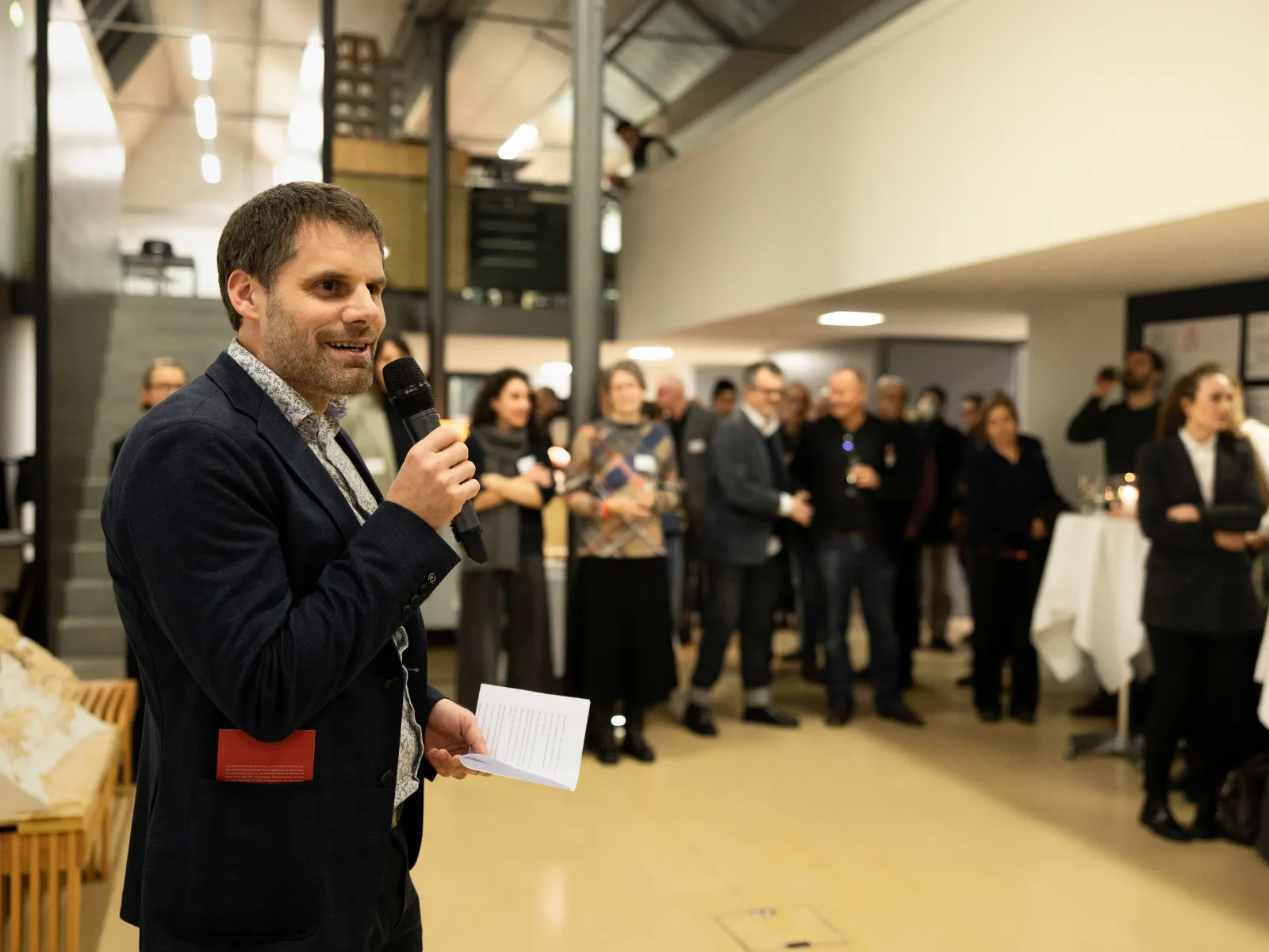 Ein Mann spricht vor einer Gruppe von Menschen in ein Mikrofon