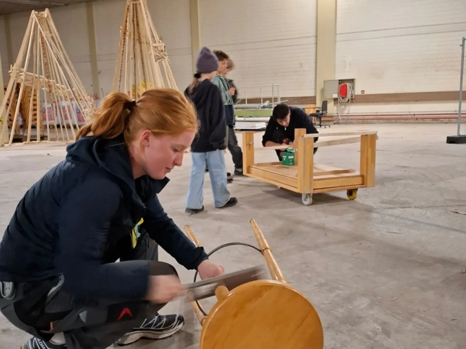 Drei Jugendliche arbeiten handwerklich mit Holz