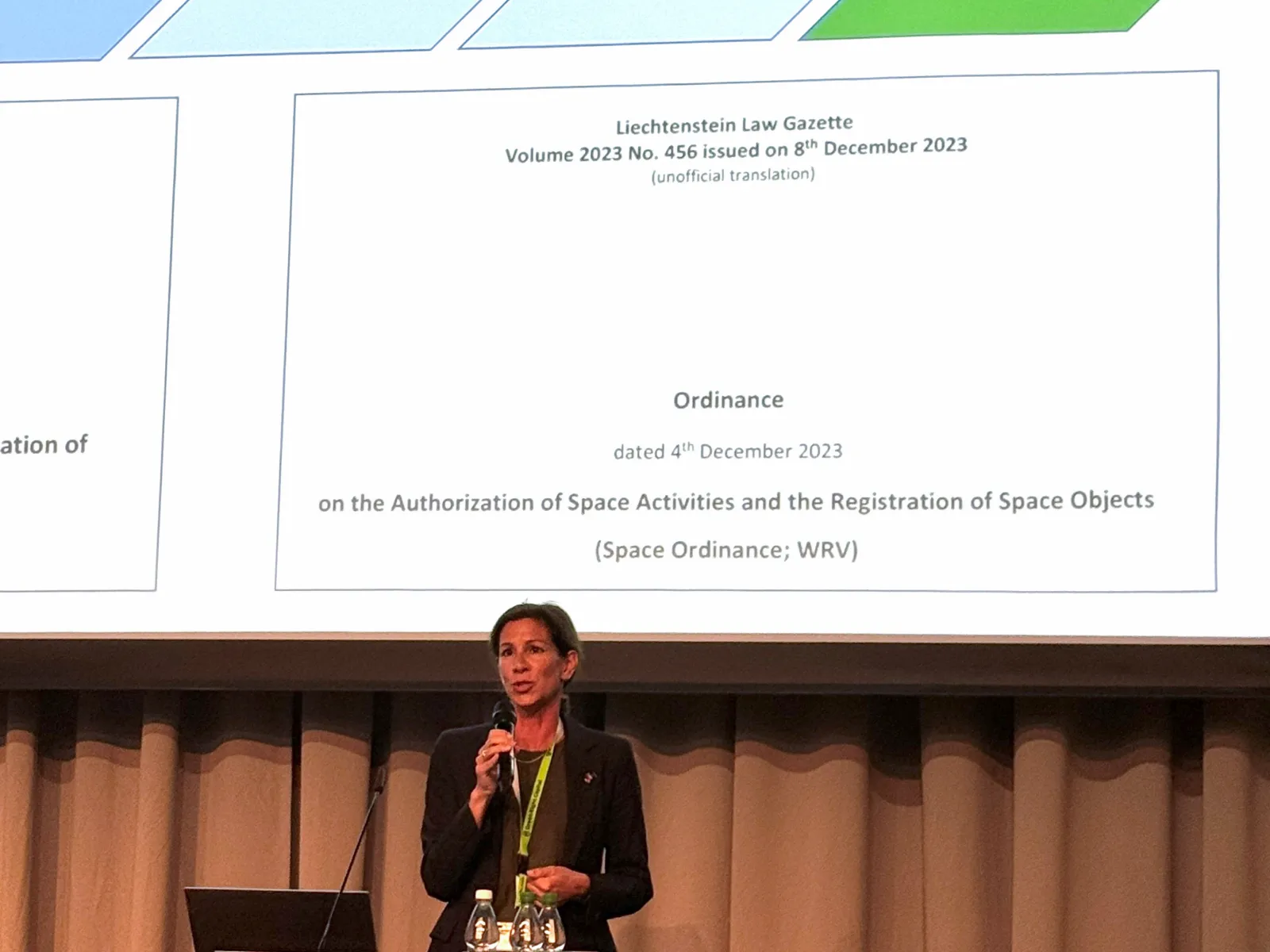 Referentin präsentiert juristische Inhalte zu Raumfahrtgesetzgebung vor Präsentationsfolie bei Fachsymposium
