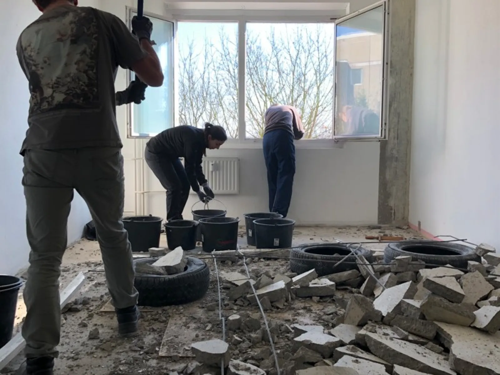 Drei Menschen brechen Wände in einem Raum ab