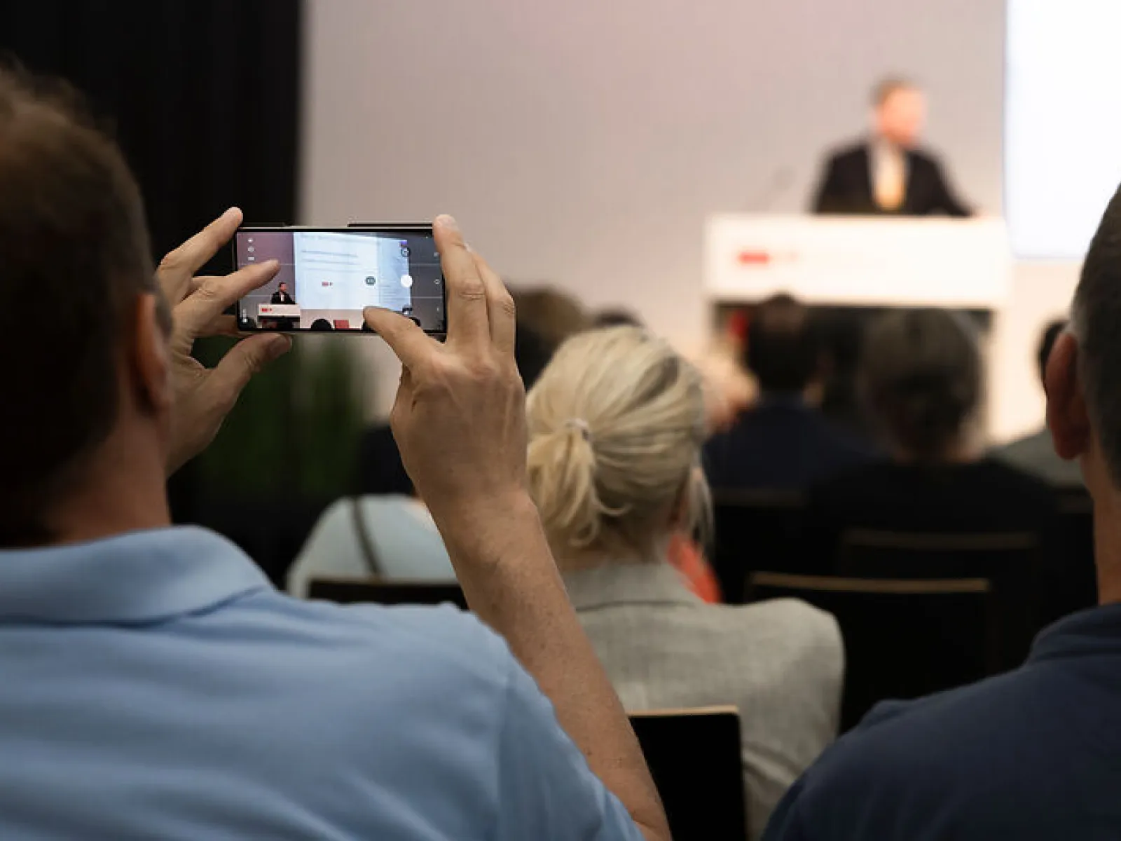 Gast fotografiert einen Vortrag beim Campus-Gespräch der Universität Liechtenstein