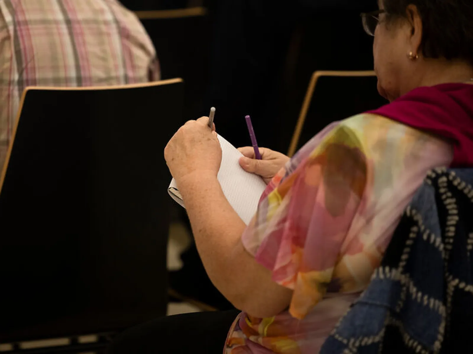 Besucherin macht sich Notizen beim Campus-Gespräch der Universität Liechtenstein