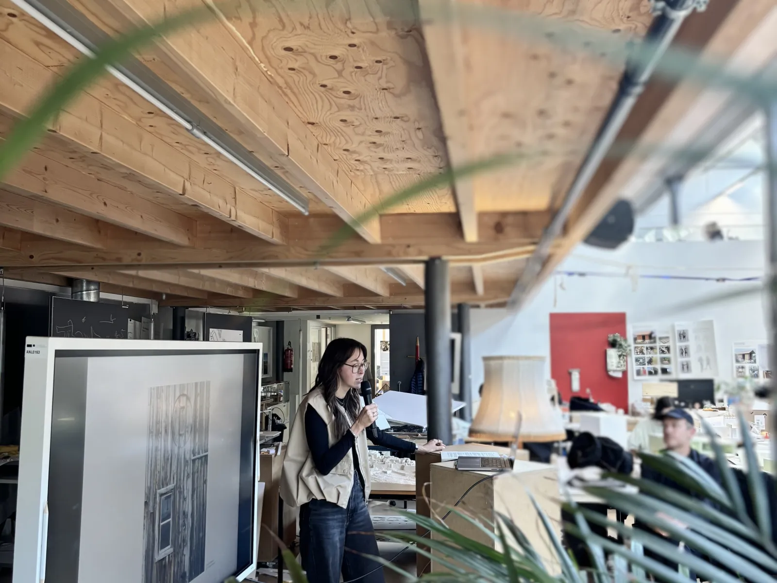 Eine Vortragende mit einer Pflanze im Vordergrund