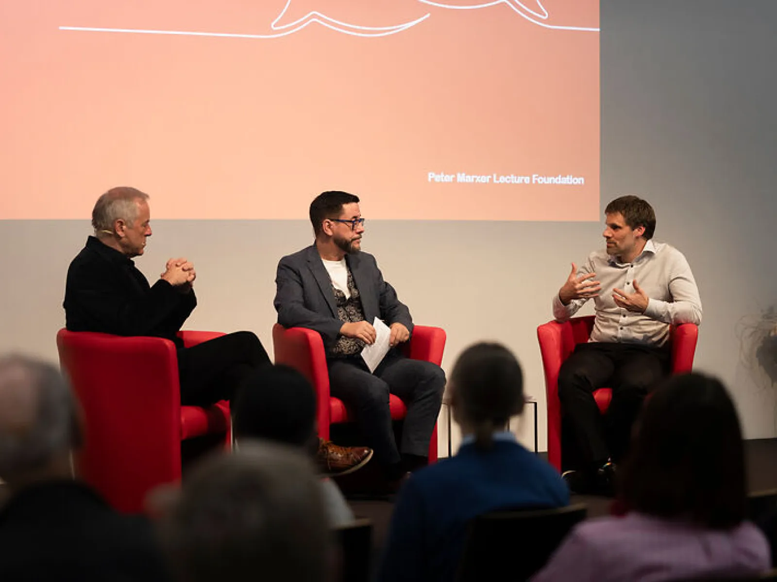 Drei Gesprächspartner diskutieren auf der Bühne vor Publikum beim Campus-Gespräch