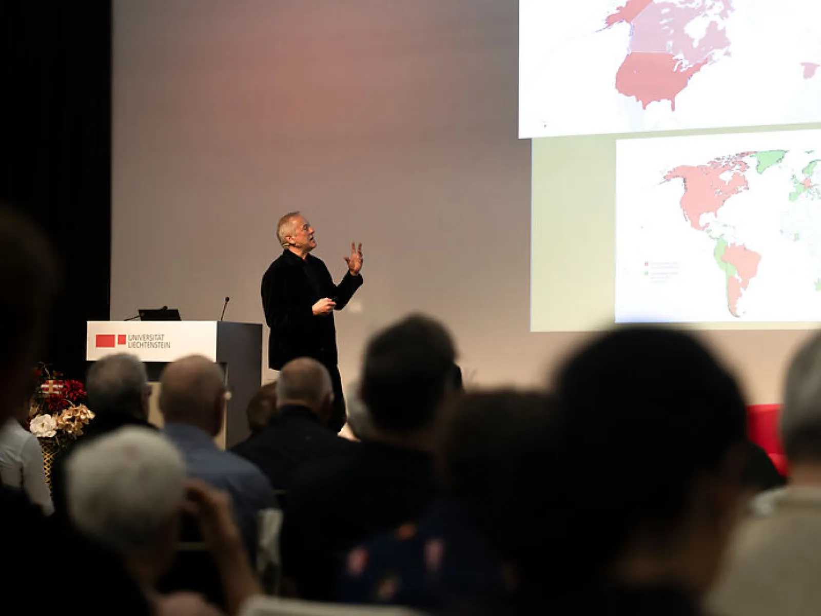 Redner präsentiert Bildinhalte vor Publikum beim Campus-Gespräch
