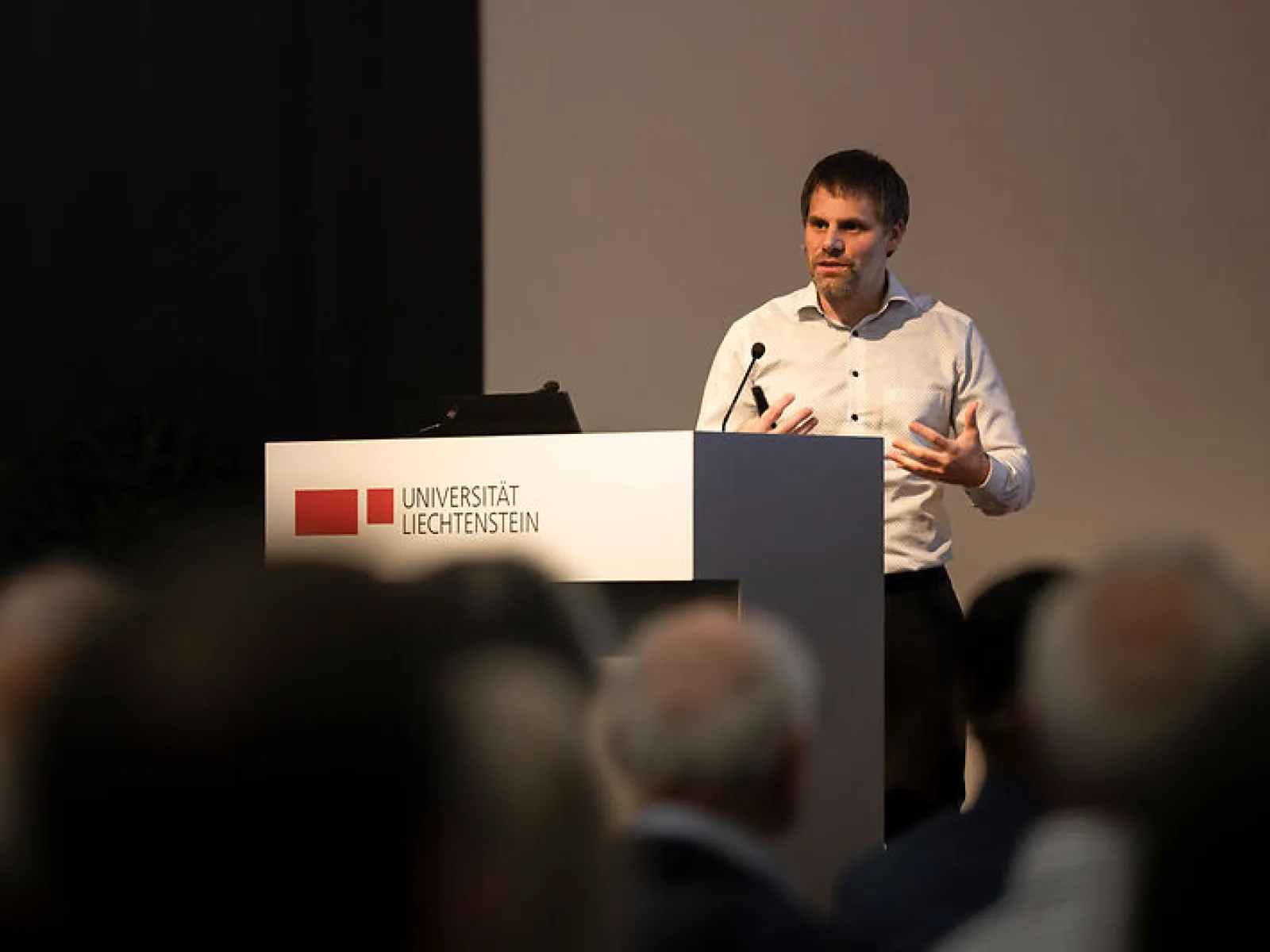 Redner spricht am Podium vor Publikum beim Campus-Gespräch