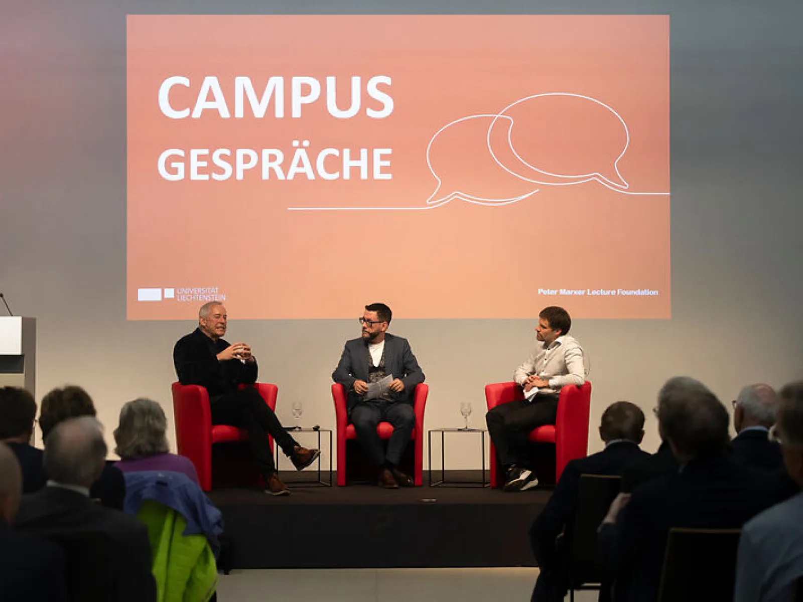 Zwei Gesprächspartner im Austausch auf der Bühne vor Publikum beim Campus-Gespräch
