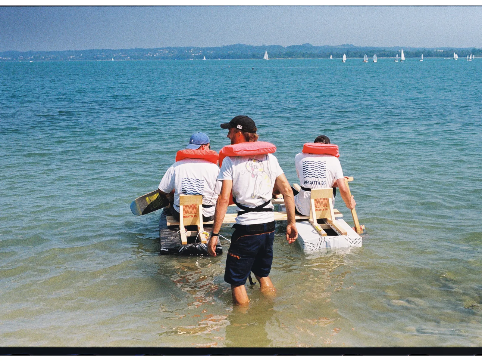 Zwei Menschen mit Schwimmweste in einem selbstgebauten Boot. 