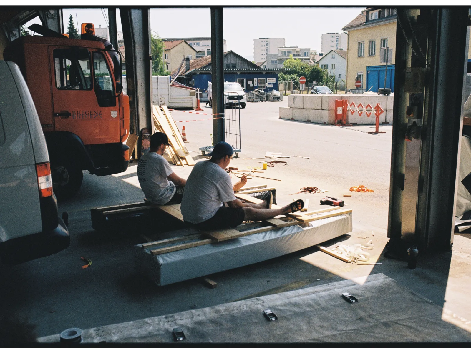 Zwei junge Männer sitzen in einer Werkstatt auf einem selbstgebauten Boot