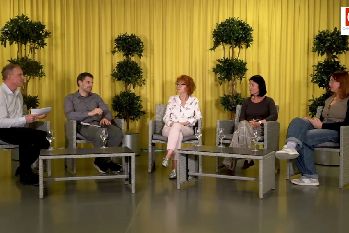 Podiumsdiskussion an der Universität Liechtenstein: Fünf Personen sitzen in einem Studio mit gelbem Vorhang und Pflanzen im Hintergrund. Sie diskutieren über Medienvielfalt und künstliche Intelligenz.