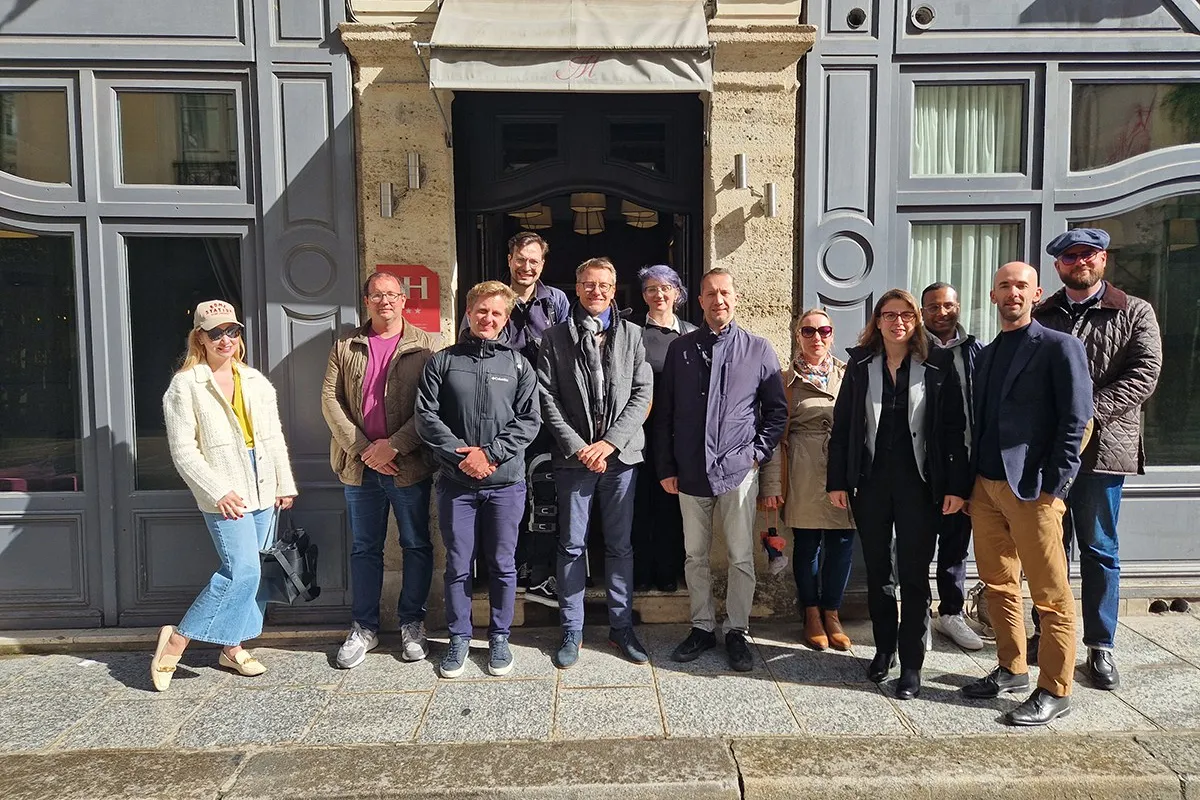 Eine Gruppe von Studierenden und Dozenten des Executive Master of Laws (LL.M.) im Wirtschaftsstrafrecht steht vor einem Gebäude in Straßburg während ihrer Studienreise zum Europarat. Sie lächeln in die Kamera und tragen verschiedene Freizeit- und Businesskleidung.