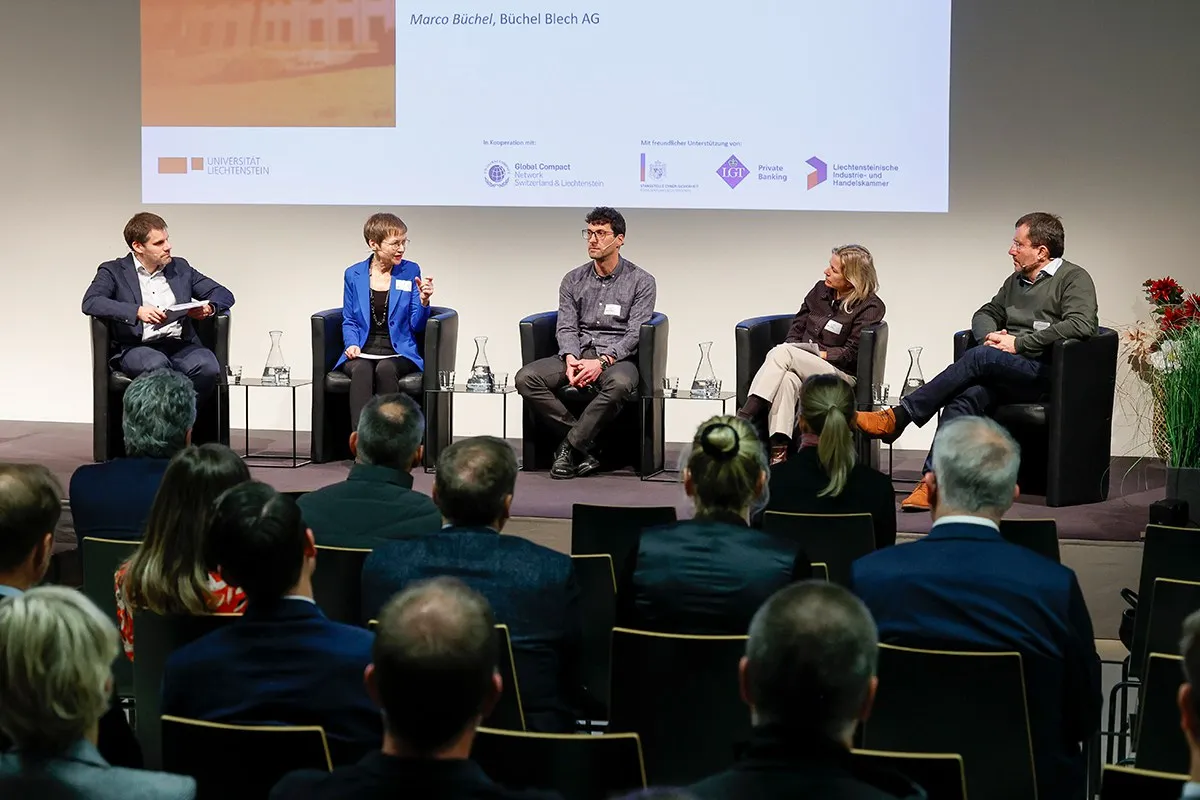 Podiumsdiskussion an der Universität Liechtenstein mit fünf Personen auf einer Bühne, die vor einem Publikum über Nachhaltigkeitsthemen sprechen. Im Hintergrund ist eine Präsentation zu sehen.