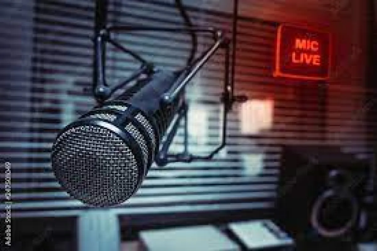 "Nahaufnahme eines Mikrofons in einem Radiostudio mit leuchtendem 'Mic Live'-Schild im Hintergrund. Perfekt für Podcasts und Interviews.