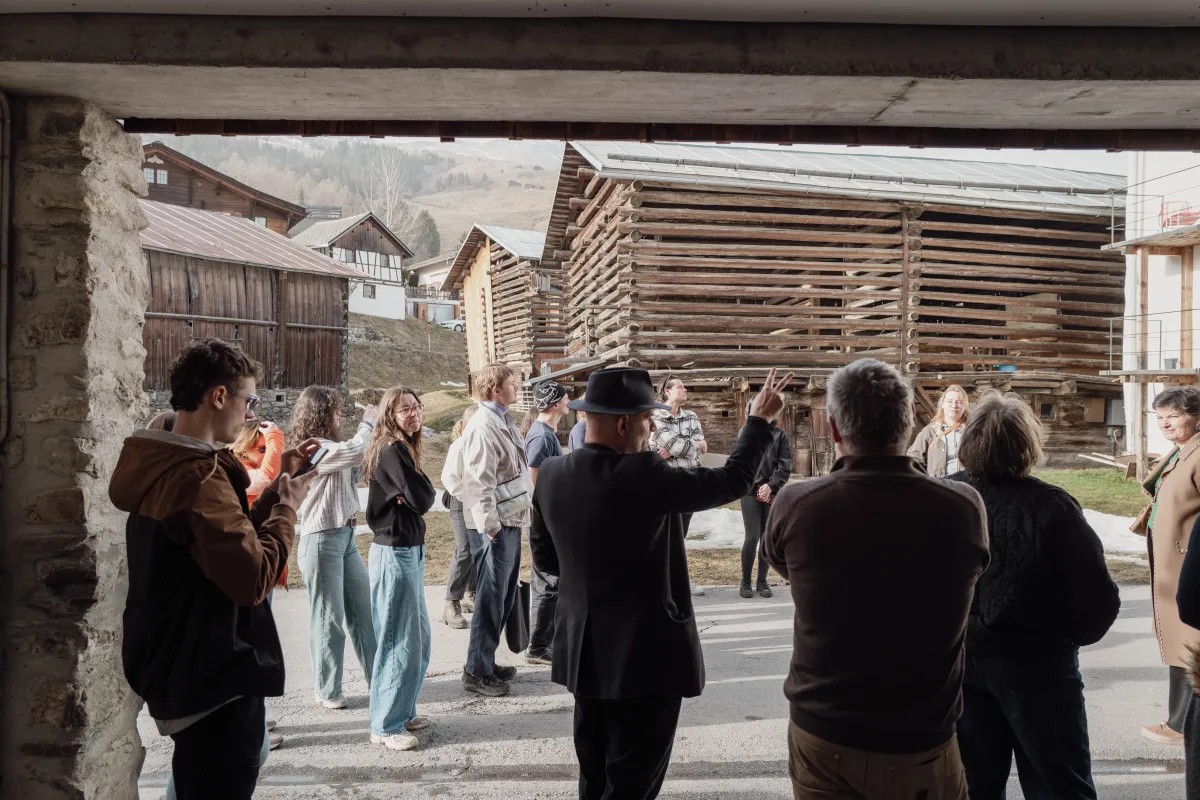 Gruppe von Menschen in einem Dorf mit Holzhäusern
