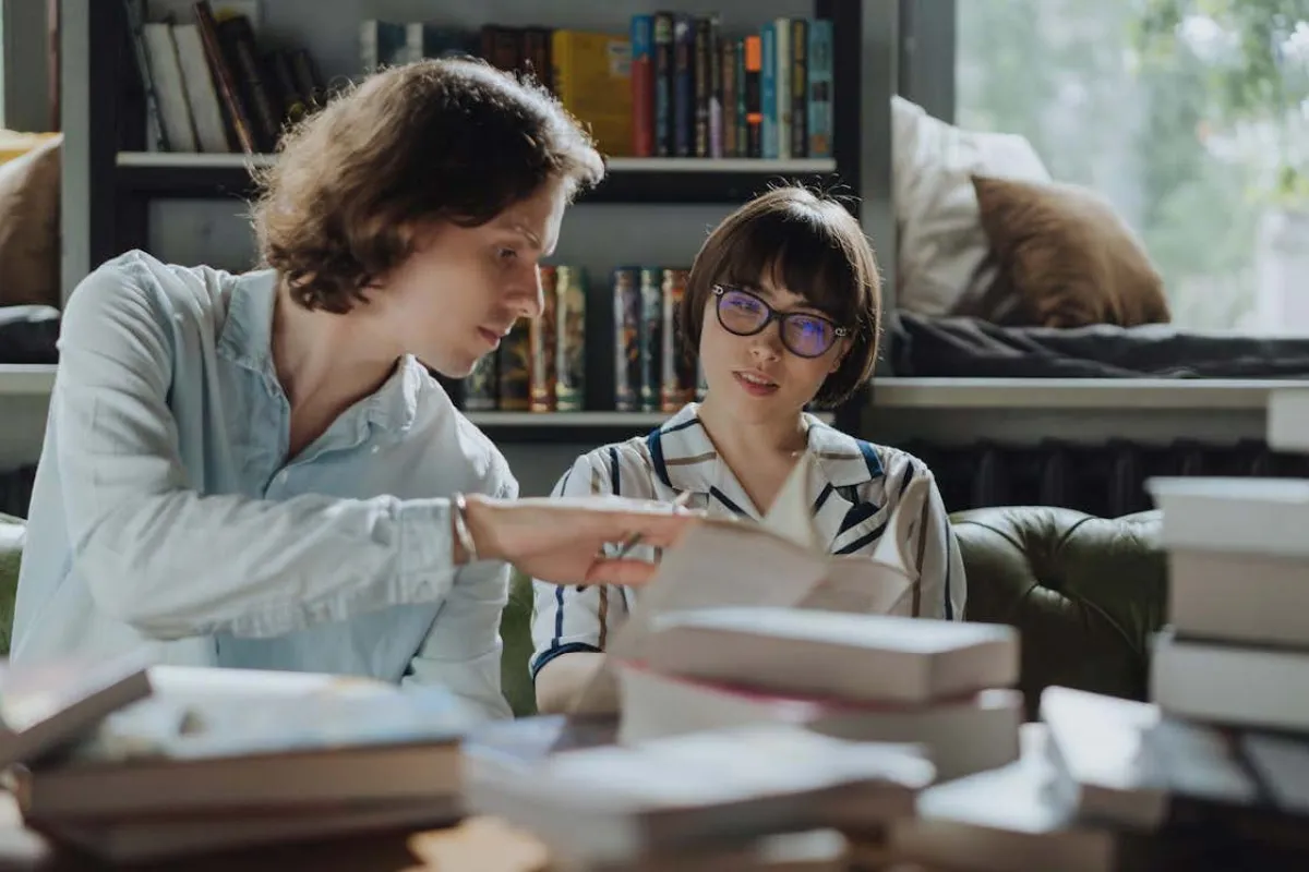 zwei Studierende schauen sich ein Buch an
