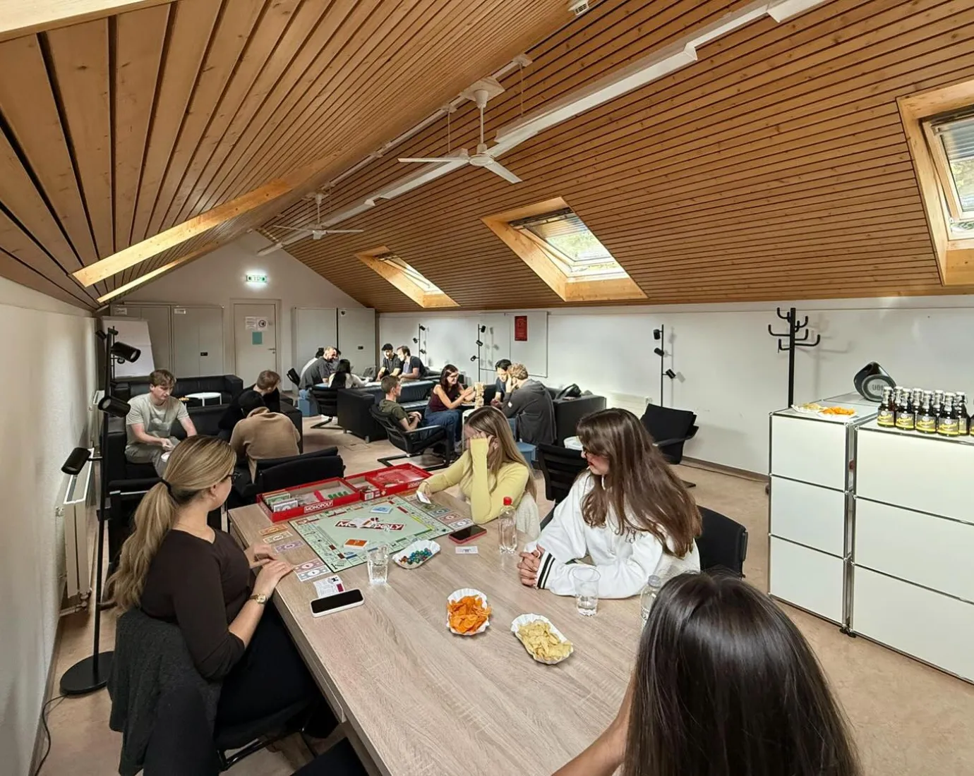 Mehrere Studierende sitzen in einem Raum und spielen