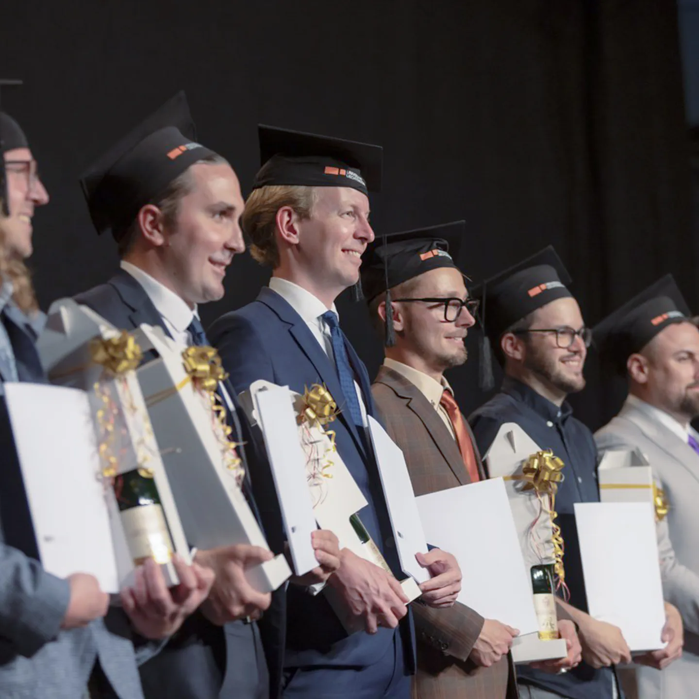 Absolventen mit Urkunden und Graduierungshüten bei der Abschlussfeier der Universität Liechtenstein