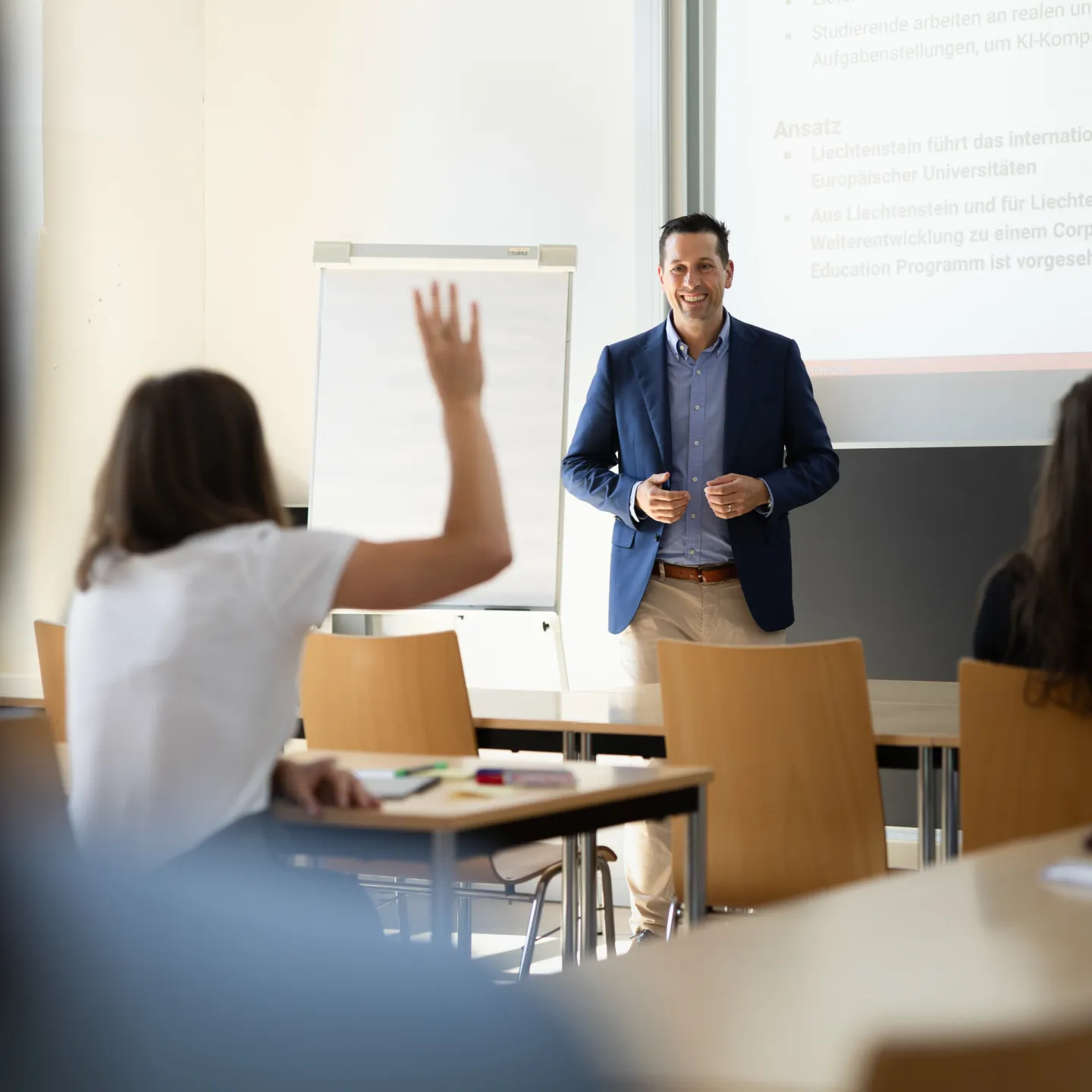 Dozent beantwortet eine Frage während einer interaktiven Lehrveranstaltung mit motivierten Studierenden.