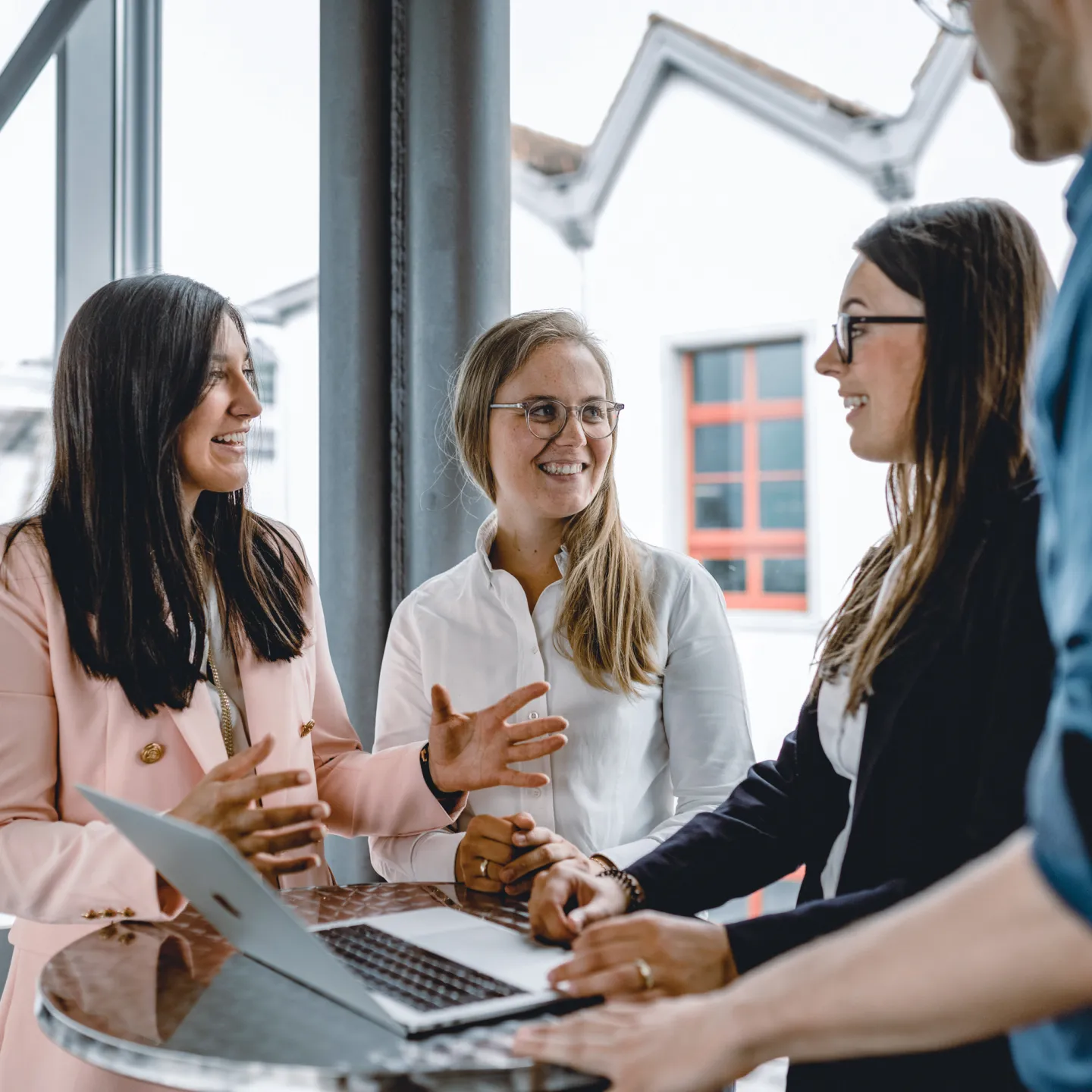 Eine Gruppe Studierende stehen im Gebäude der Universität Liechtenstein um einen Tisch