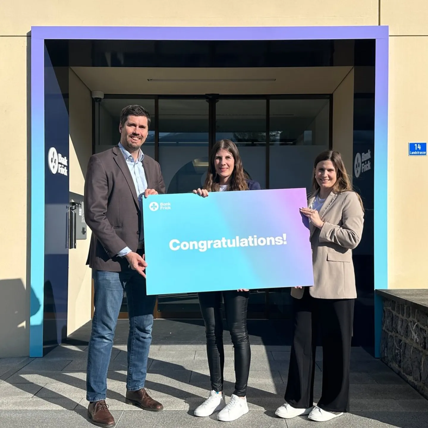 Sabrina Zimmermann, die Stipendiatin von Bank Frick, steht vor dem Gebäude der Bank Frick, bereit, am CAS Blockchain und Fintech Programm teilzunehmen.