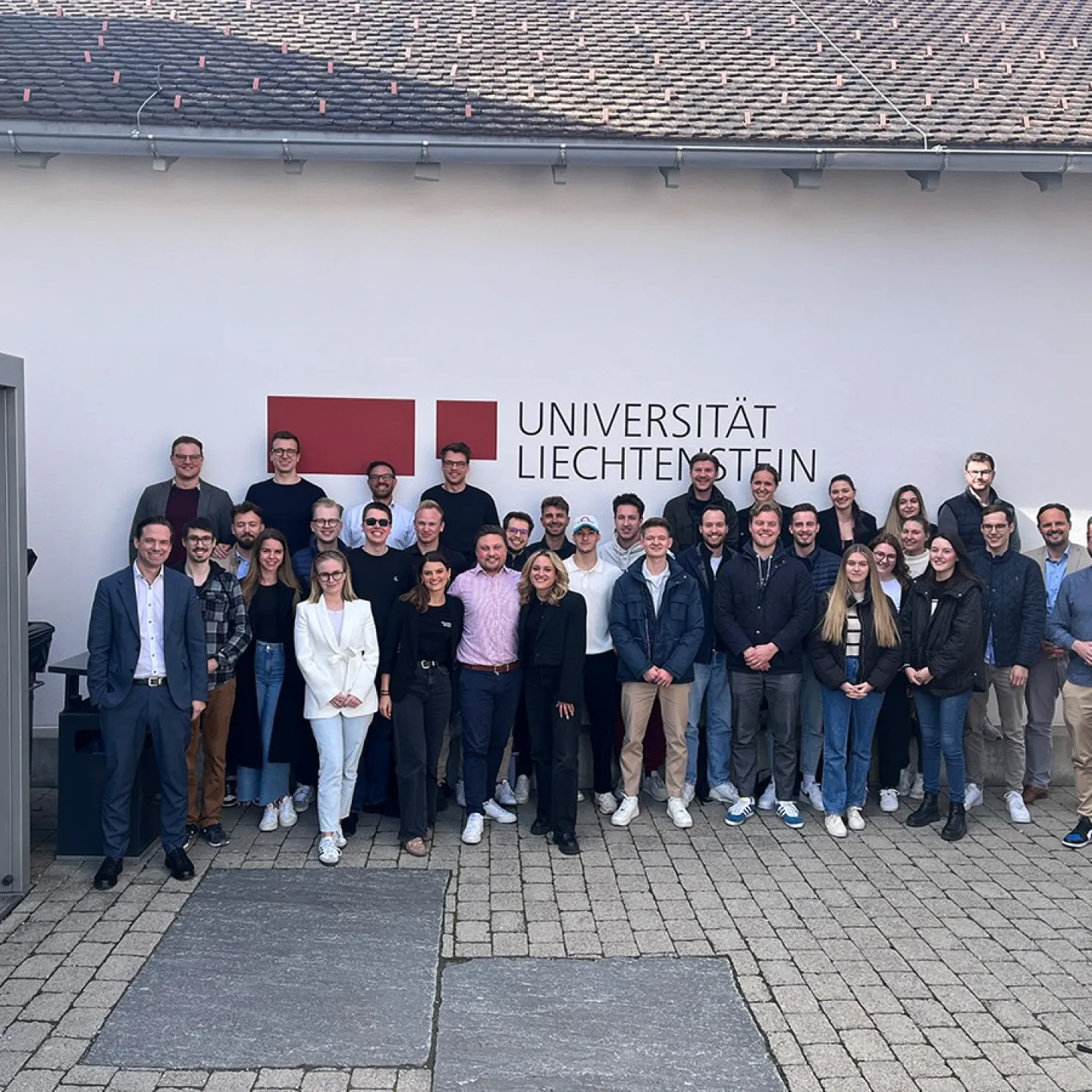 Gruppe von Studierenden und Jury-Mitgliedern des Startup Labs vor dem Gebäude der Universität Liechtenstein, aufgenommen bei den Mid-Term-Präsentationen des Masterstudiengangs Entrepreneurship und Management.