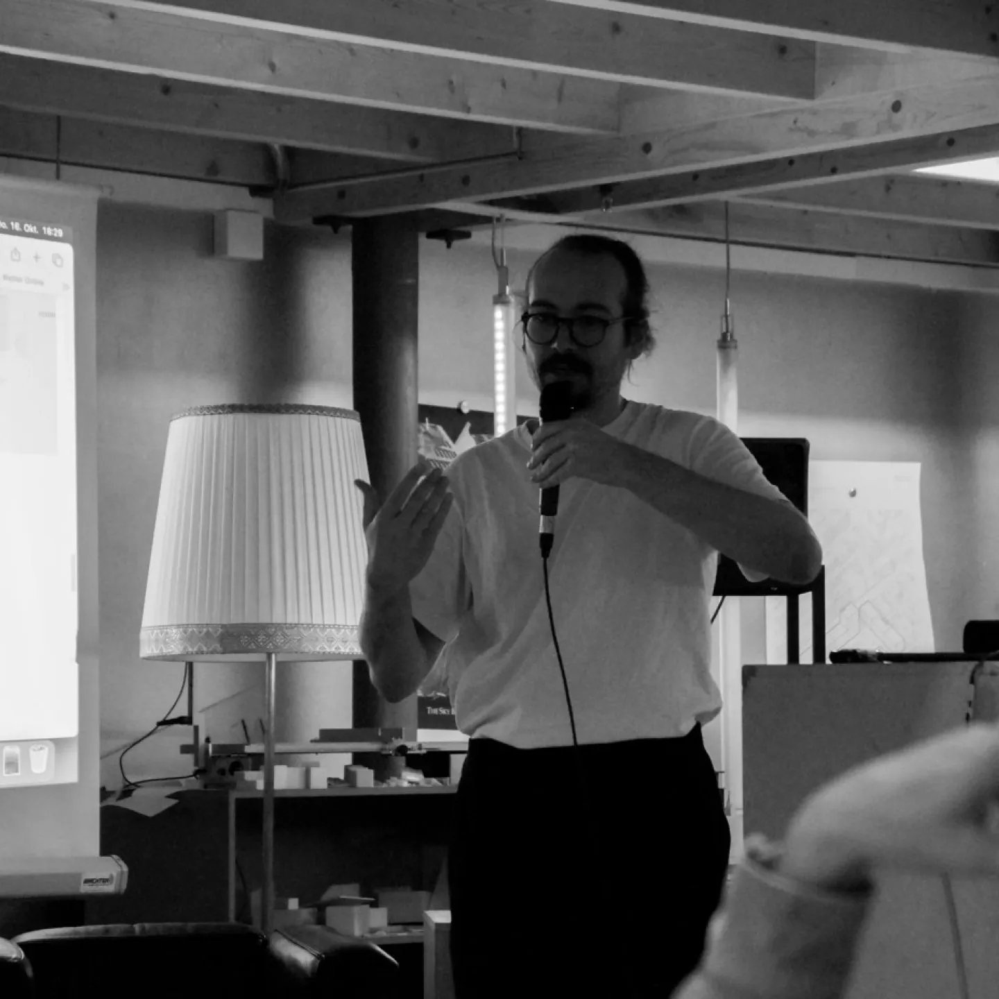 Schwarz-Weiss Aufnahme eines Mannes mit einem Mikrofon in der Hand