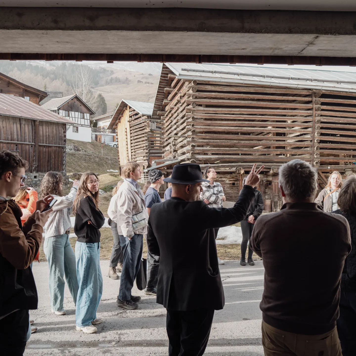 Gruppe von Menschen in einem Dorf mit Holzhäusern