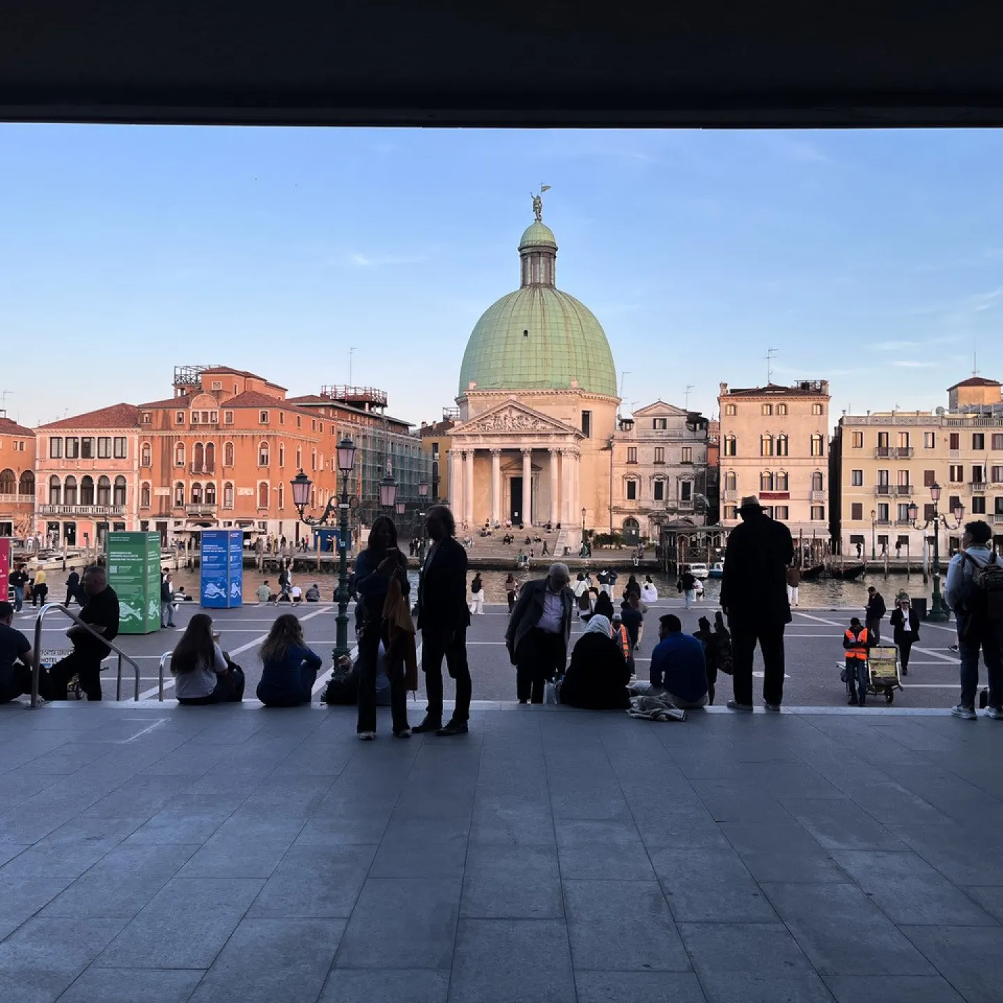 View of a square with domed building and people.