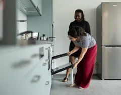 Studentinnen nutzen den Backofen in der Gemeinschaftsküche des Studierendenwohnheims der Universität Liechtenstein.