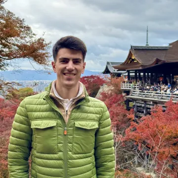 Student der Universität Liechtenstein vor Tempel und Herbstlandschaft während Auslandssemester in Japan