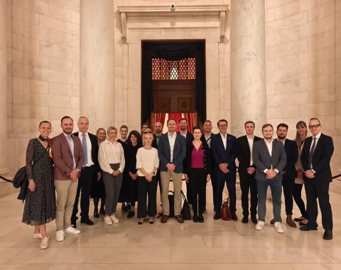 Eine Gruppe von Studierenden und Dozenten steht in einem eleganten, marmorgekleideten Innenraum. Sie posieren für ein Gruppenfoto während einer Studienreise in die USA, organisiert von der Universität Liechtenstein.