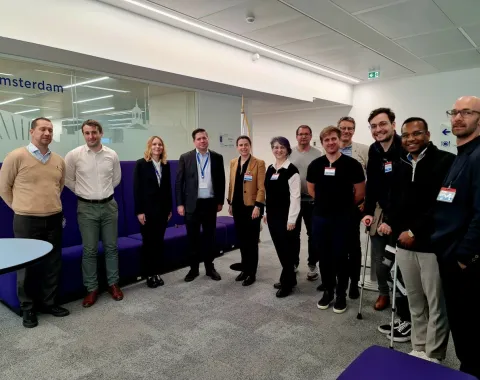 Gruppe von Studierenden und Dozenten des Executive Master of Laws (LL.M.) im Wirtschaftsstrafrecht der Universität Liechtenstein bei einer Studienreise im Europarat in Straßburg, stehend in einem modernen Konferenzraum.