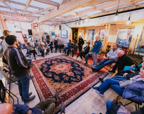 Gruppen von Menschen sitzt in einem Kreis und disktutiert