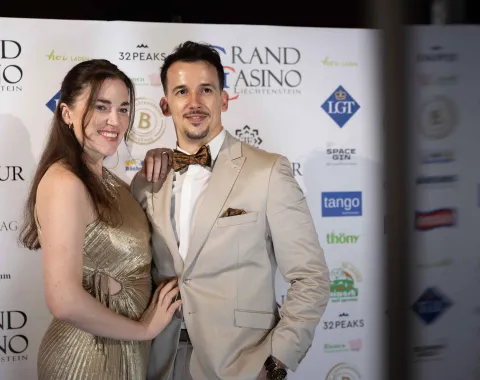 Paar-posiert-vor-Sponsorenwand-Uniball-Uni-Liechtenstein