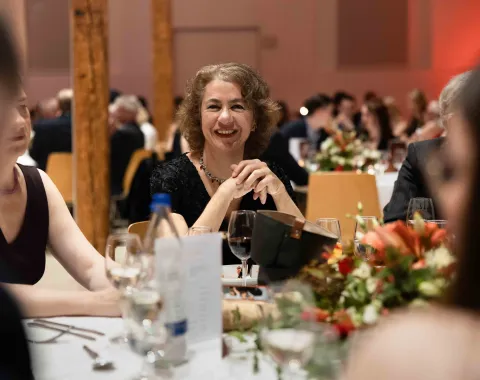 Laechelnde-Frau-am-Tisch-Uniball-Uni-Liechtenstein